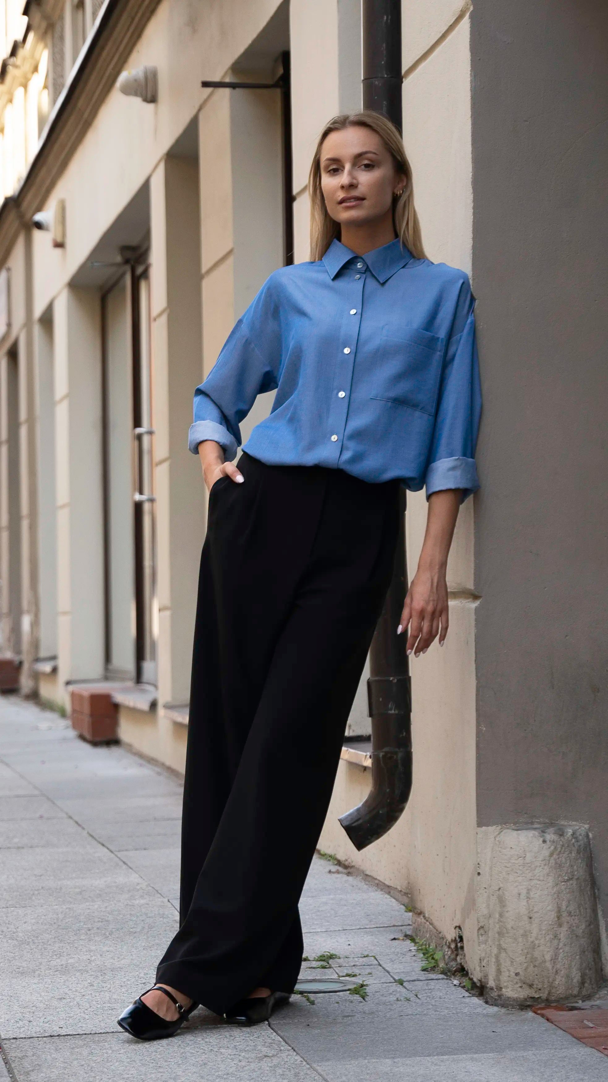 Mergina apsirengusi mėlynais klasikiniais cut my fashion marškiniais ir juodomis kelnėmis