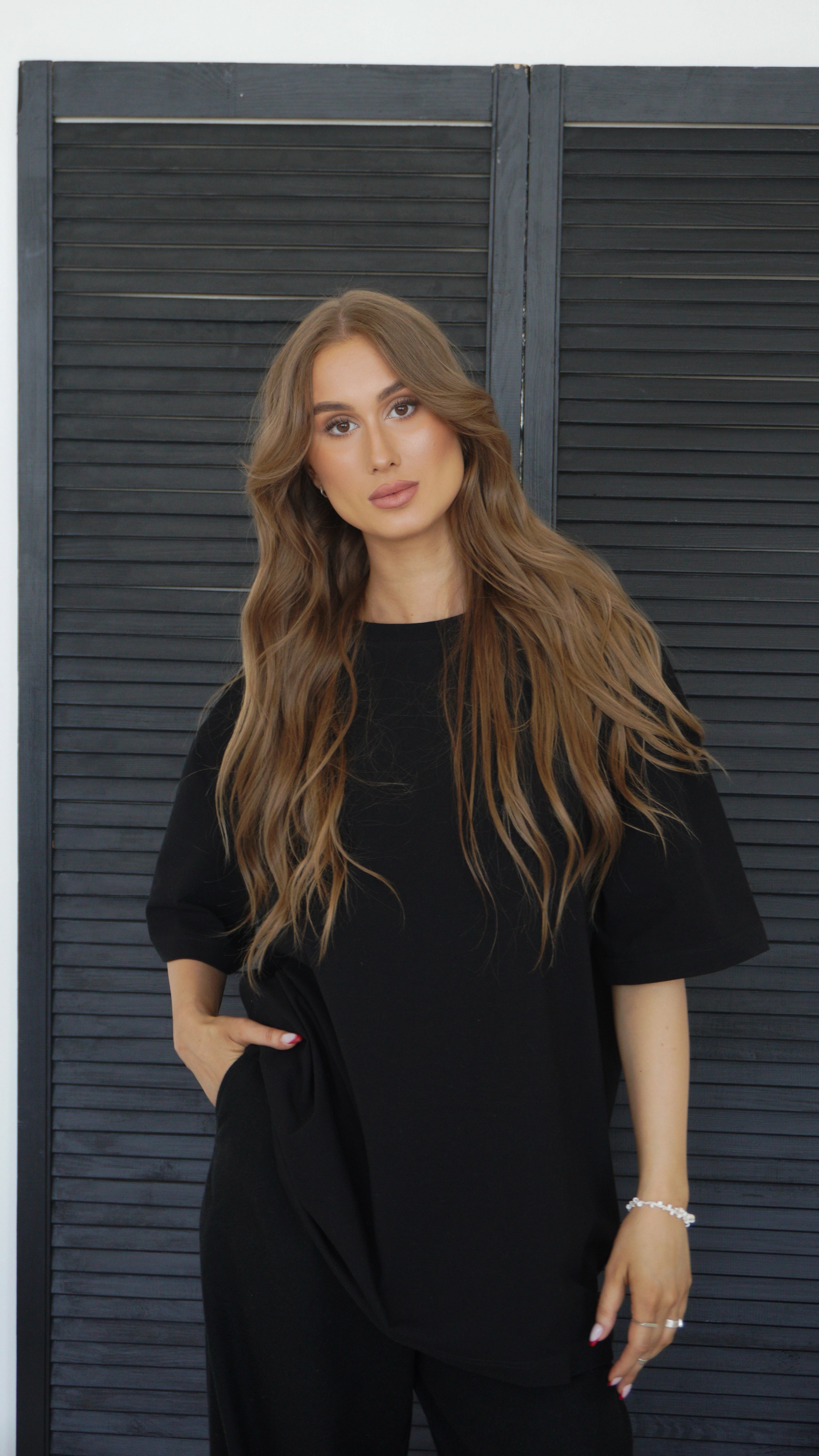 Moteris dėvi juodus oversized moteriškus marškinėlius