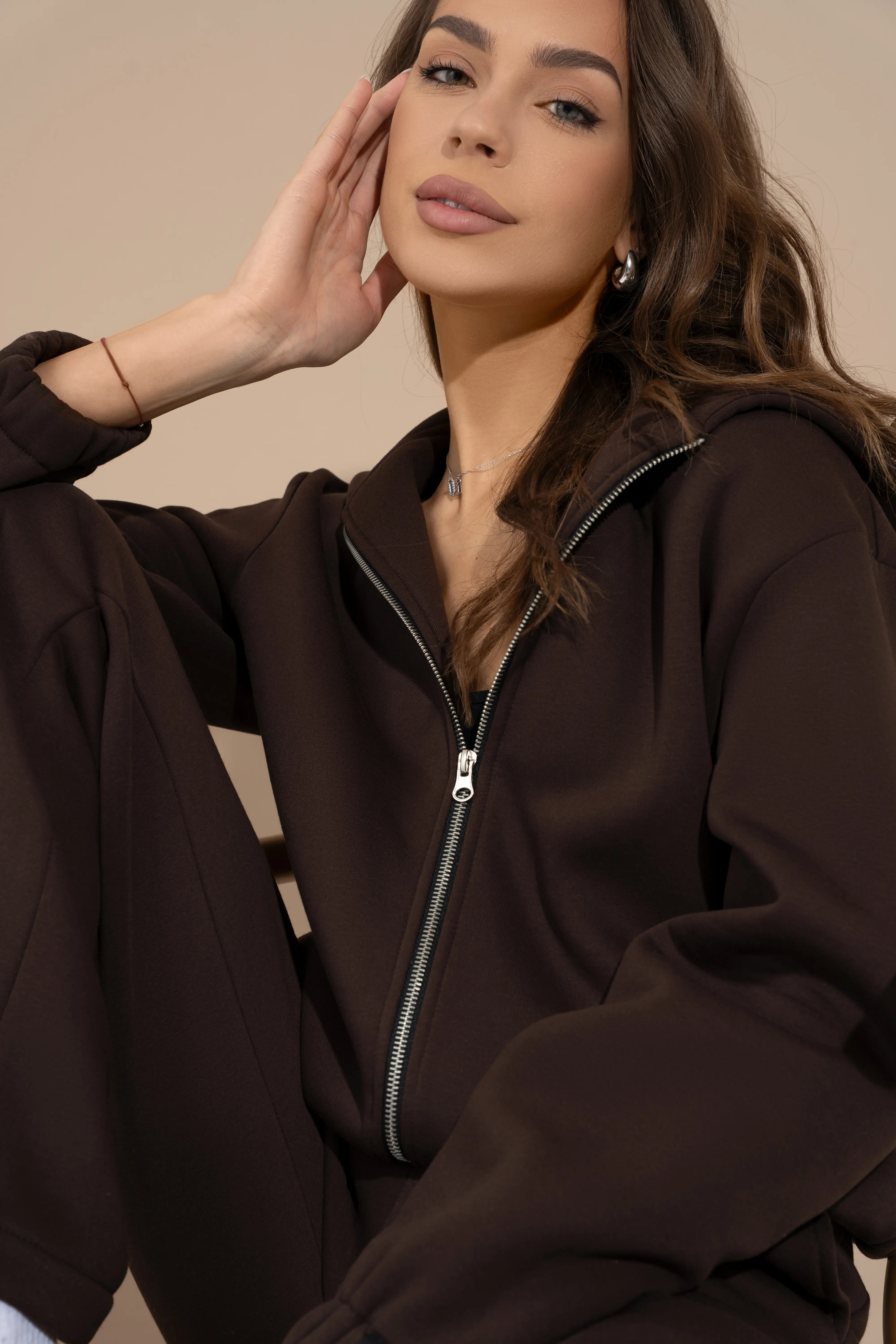 Rudos spalvos moteriško džemperio su gobtuvu metalinio pilno ilgio užtrauktuko ir apykaklės detalė