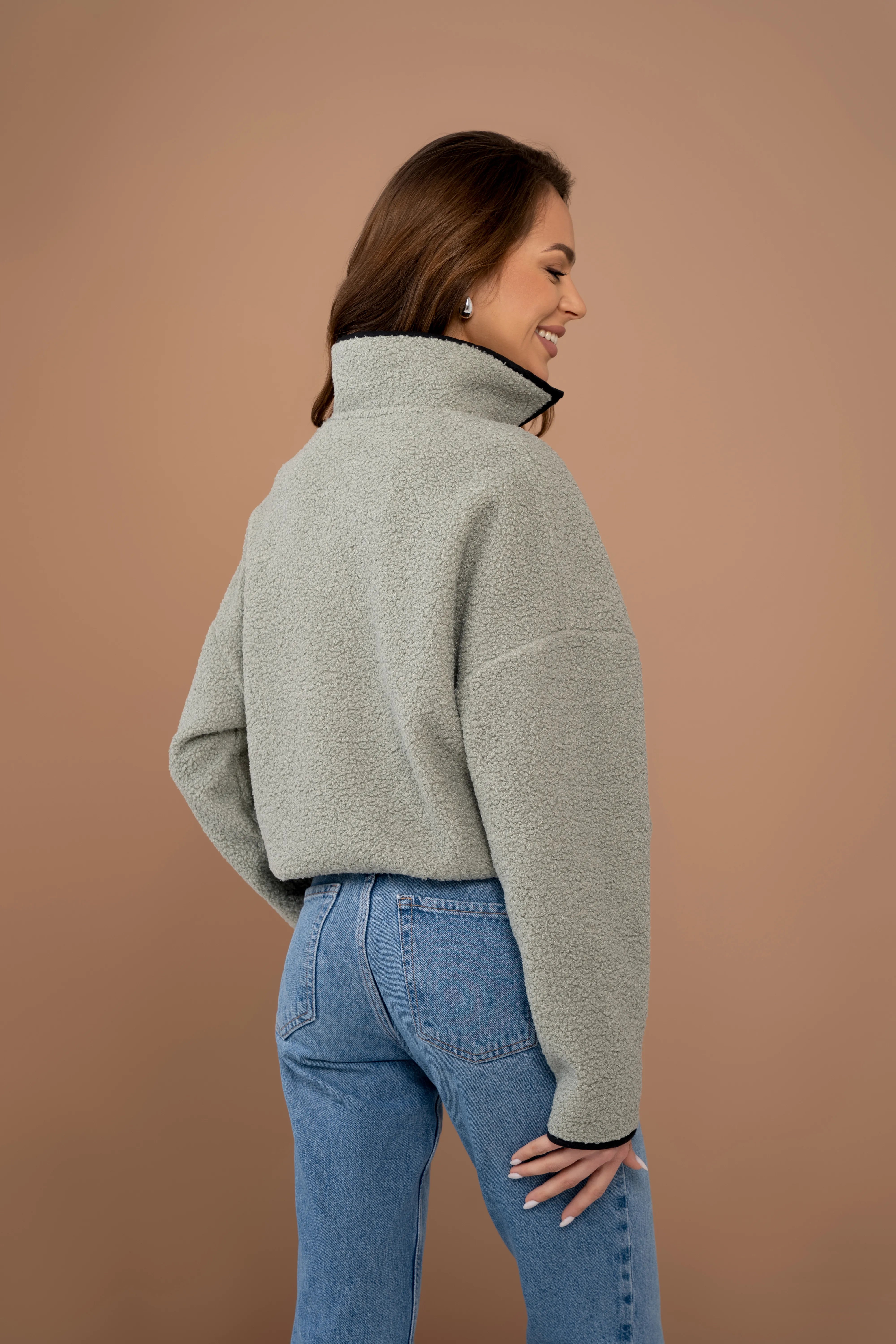 Chaki spalvos moteriškas džemperis iš nugaros su stačia apykakle, ilgomis rankovėmis ir tiesia nugaros linija