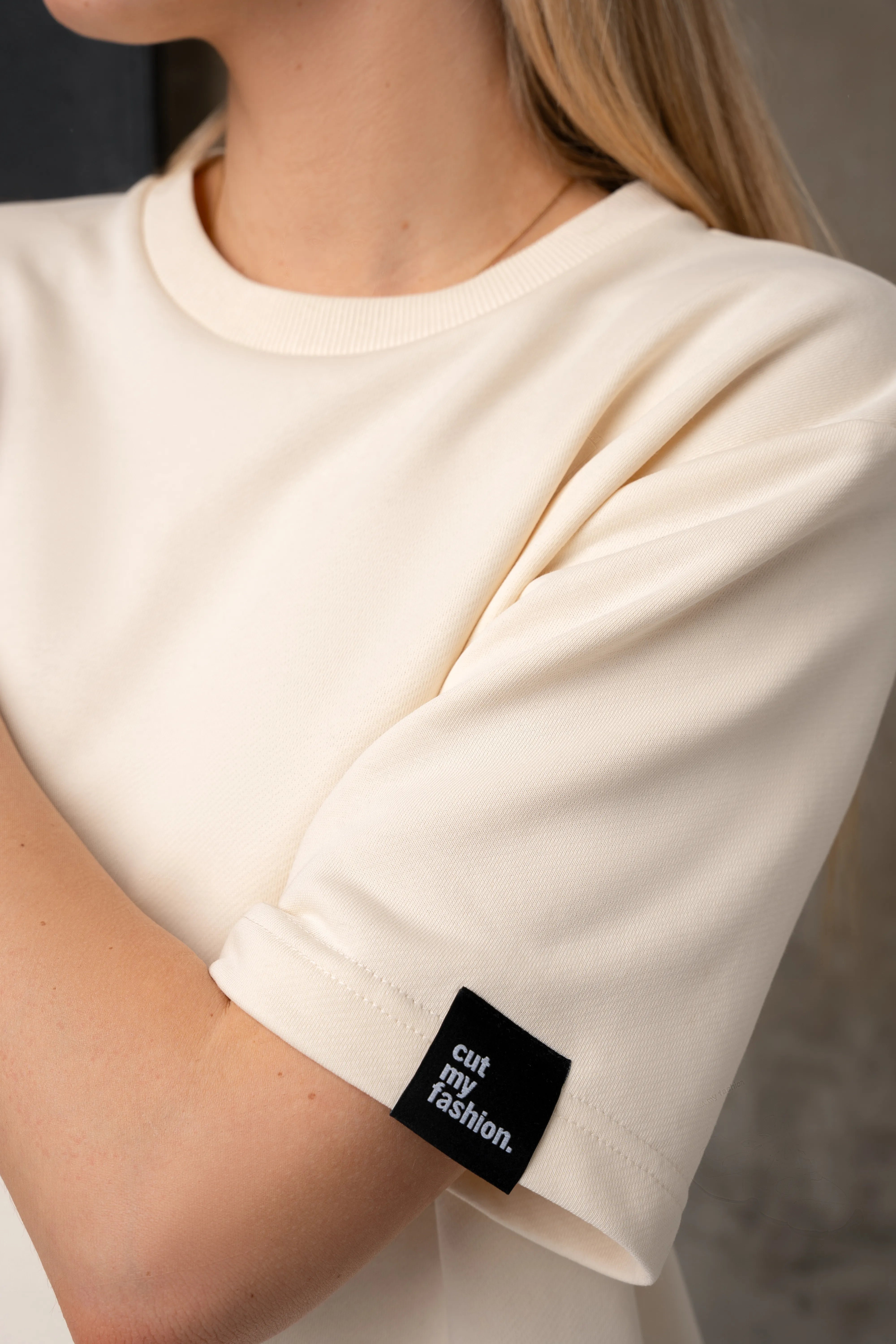 Pieno baltumo palaidinės rankovės detalė su juodu cutmyfashion logotipu
