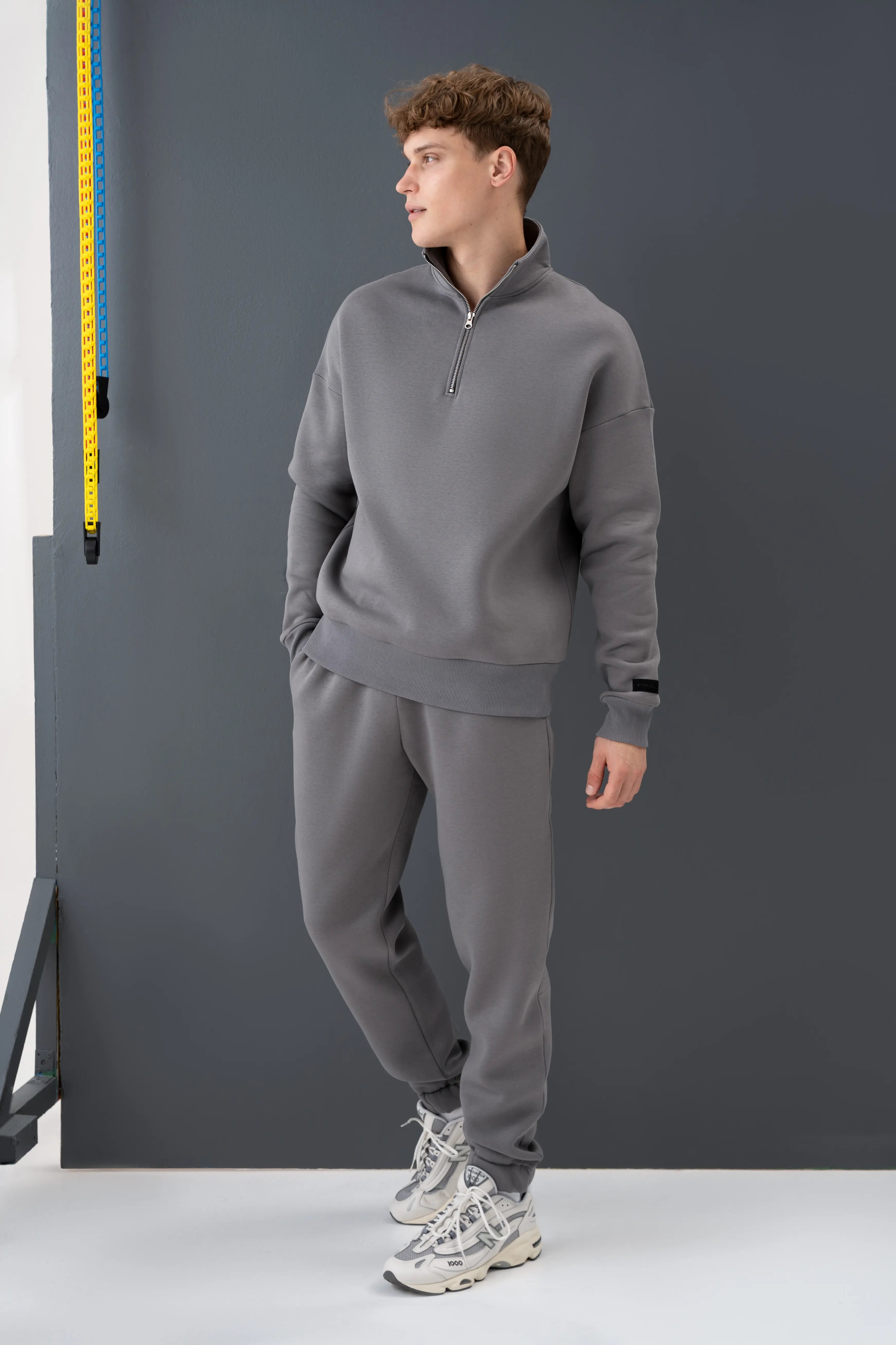 Pilkas vyriškas laisvalaikio treningas su užtrauktuku, patogus dėvėti namuose ar mieste, pagamintas Lietuvoje cutmyfashion siuvykloje.