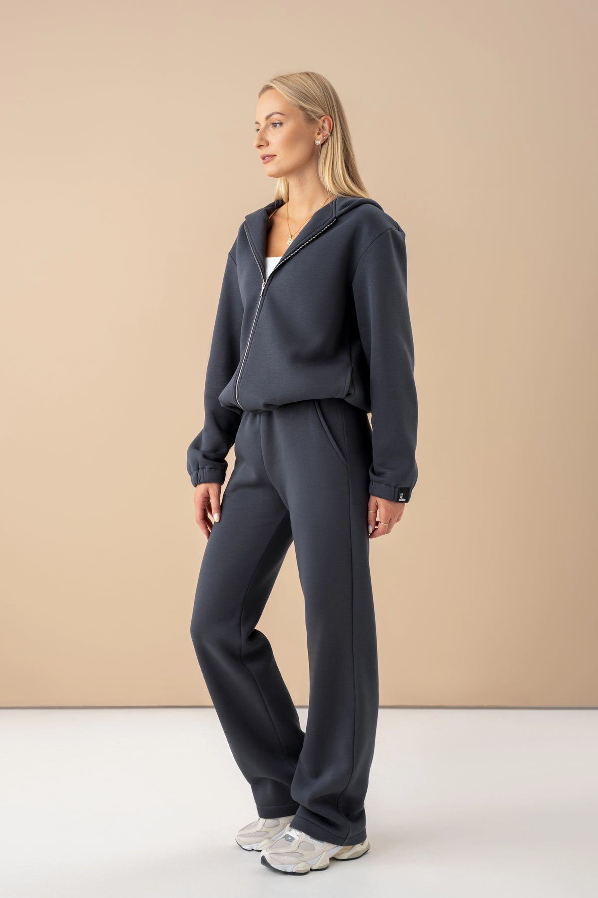 dark grey cutmyfashion tracksuit set, the model turned sideways, studio setting