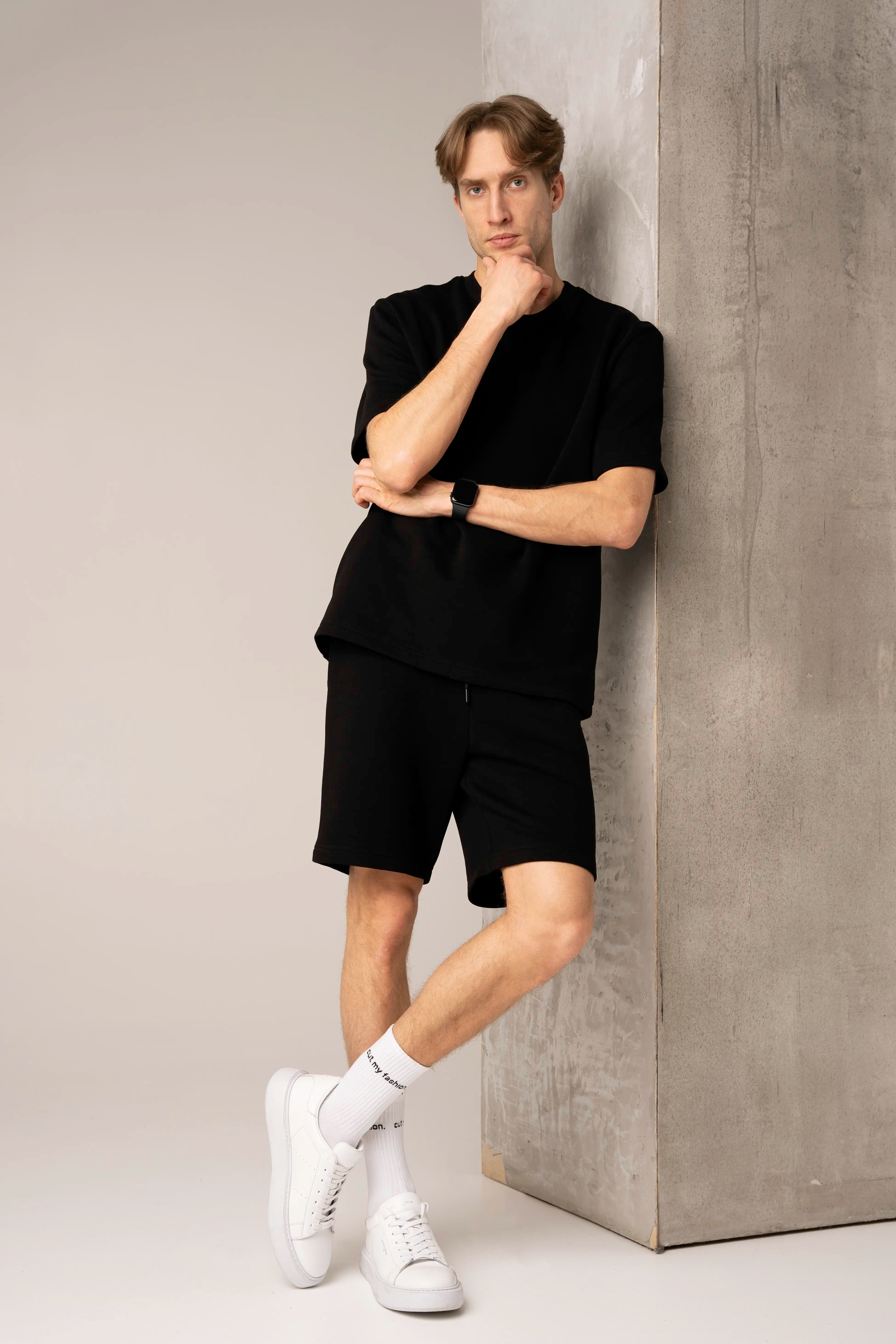 Juodos spalvos vyriškas laisvalaikio treningas su marškinėliais ir šortais su kišenėmis.