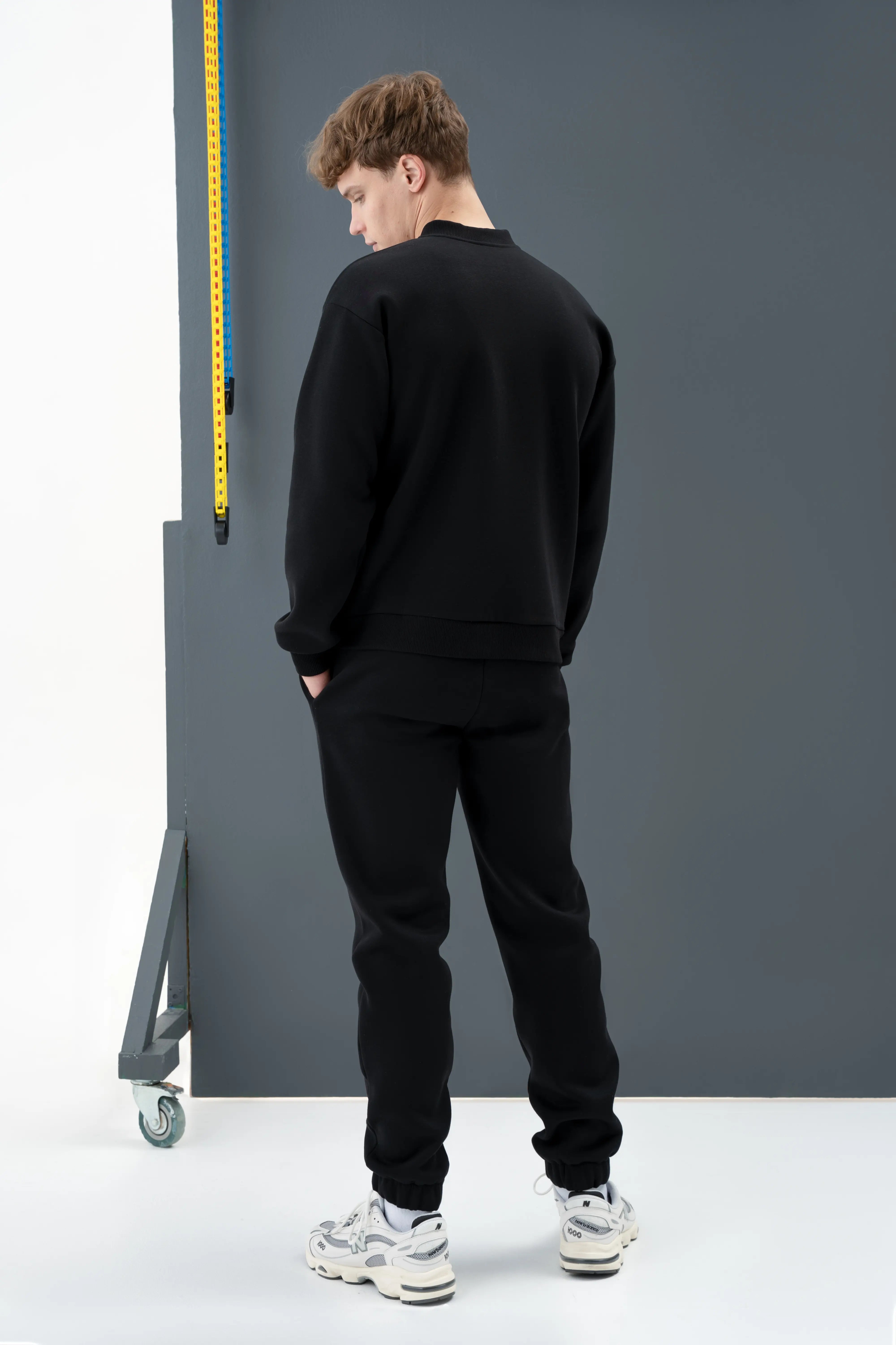 Stilingas juodas laisvalaikio treningas vyrui, puikiai tinkantis poilsiui ar pasivaikščiojimams mieste.