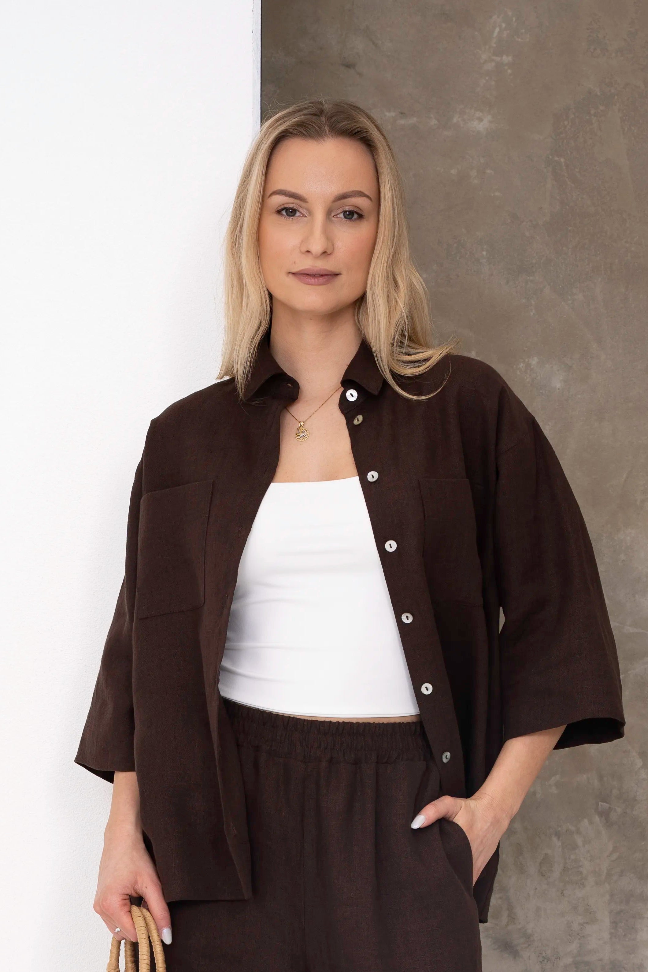 Women's linen shirt in chocolate brown, worn open with a light blouse underneath