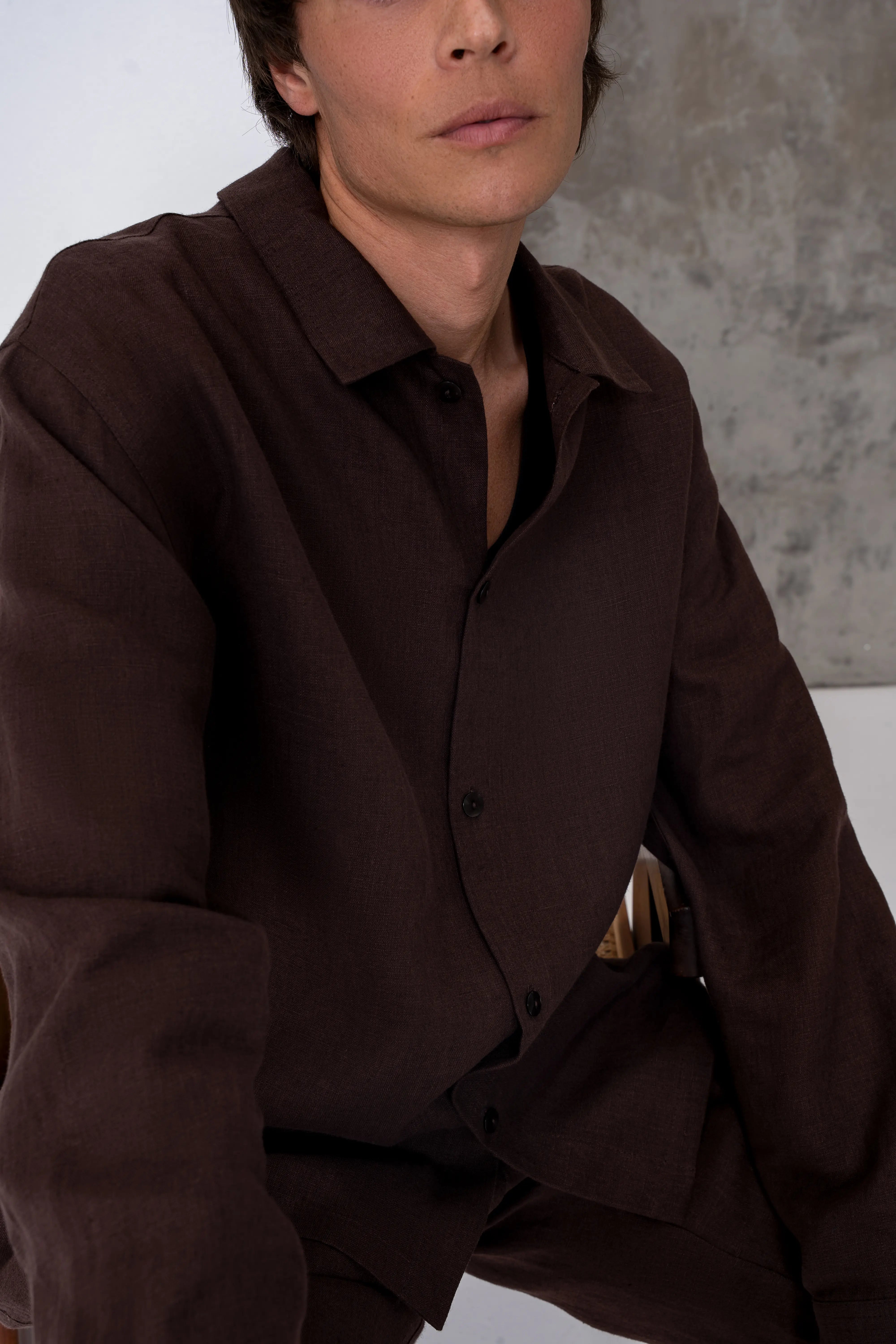 Brown men’s linen shirt close-up, loose drape and button-front fastening