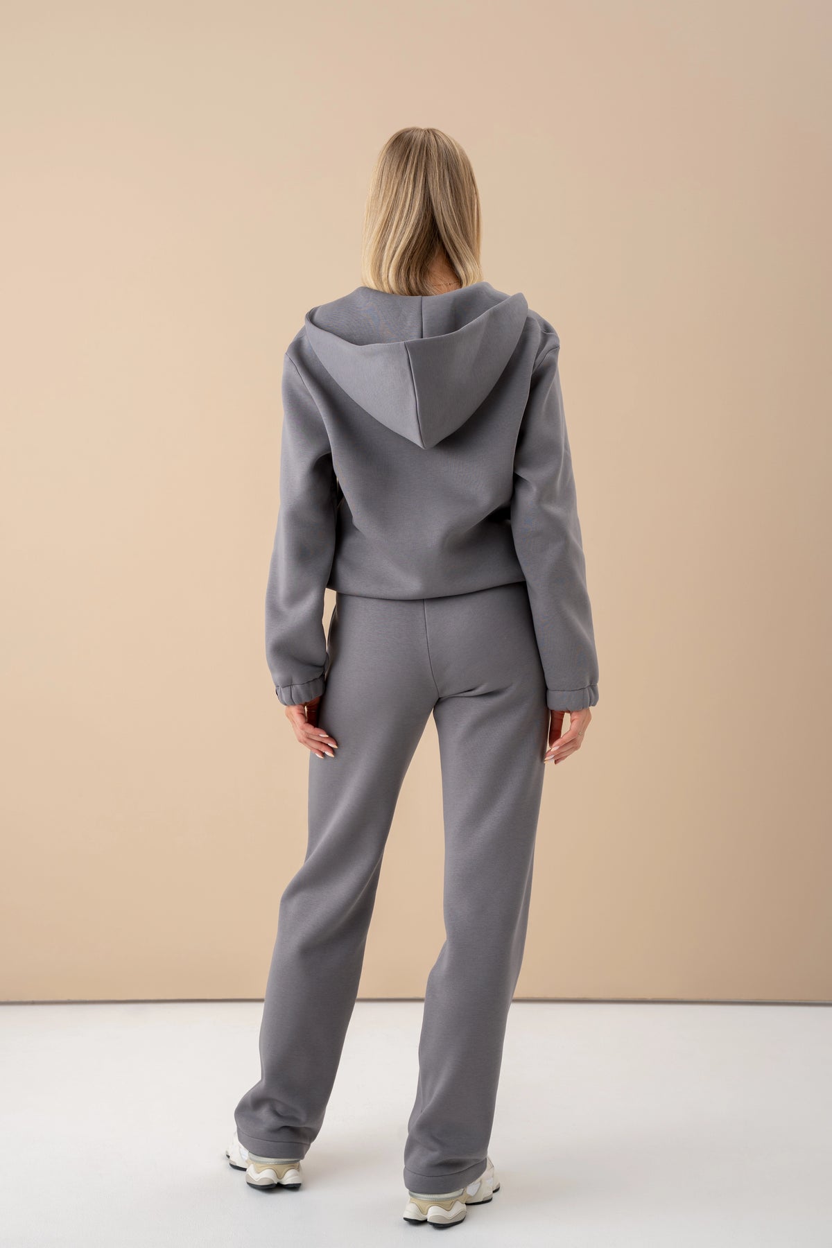 grey cutmyfashion tracksuit set, the model is standing with her back to the camera, wearing white sneakers